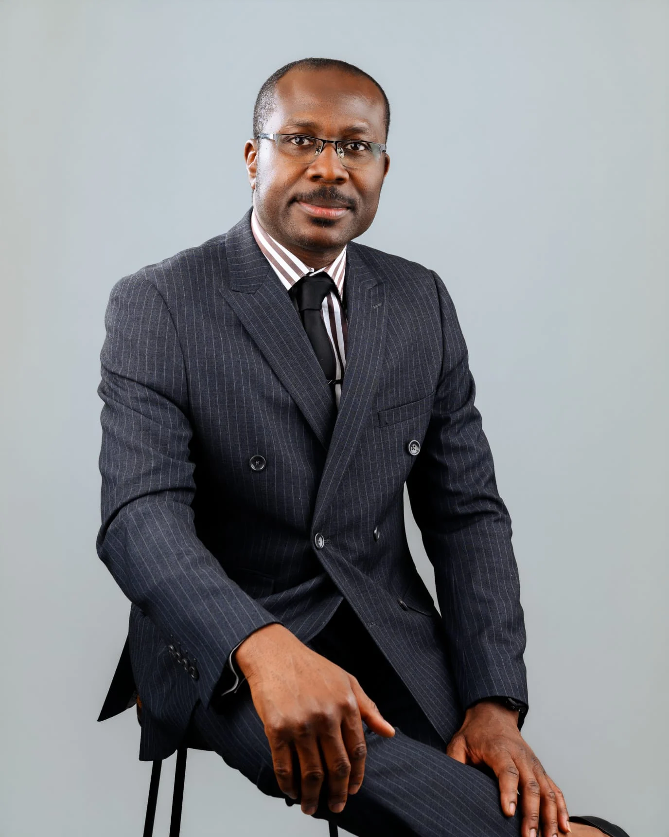 Felix Nzemeka seated in a dark suit