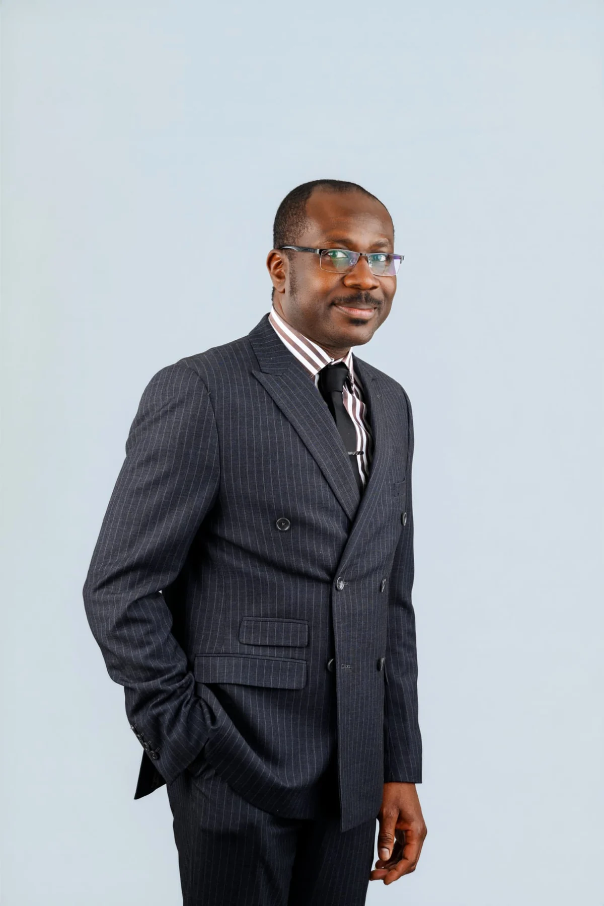 Felix Nzemeka standing in a dark suit